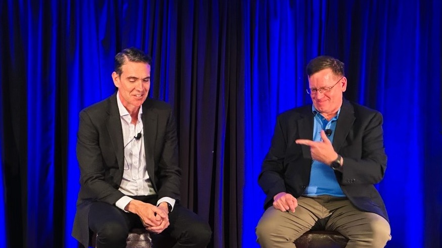 Two IANS faculty members sit on a panel on stage.